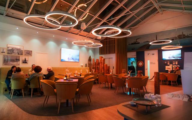 Die Lobby-bar mit Gästen die an Tischen sitzen 